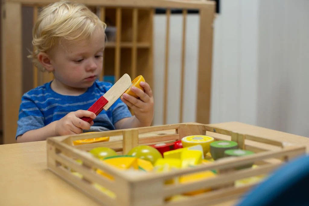 A toddler discovering a wooden classroom activity